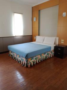 Hsin-hsien-ts'un富仙境的一间卧室配有一张带蓝色毯子的大床
