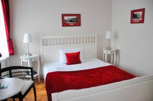 拉贝河畔乌斯季皮沃瓦纳莱切酒店的一间白色卧室,床上配有红色枕头