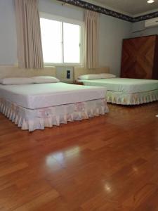 Hsin-hsien-ts'un富仙境的客房内设有两张床,铺有木地板,设有窗户。