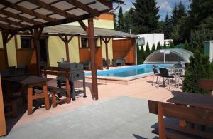 大洛西尼Apartmán Sophia 3的庭院设有带桌子和长凳的游泳池