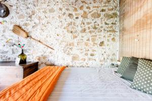 ZimbreiraPalheirinho的一间卧室设有一张床和石墙