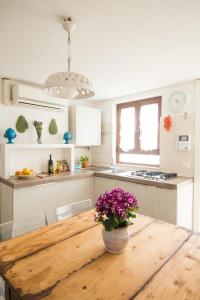 图里Manidibianco Apulian Relaxing Stay的厨房配有木桌,上面有花瓶
