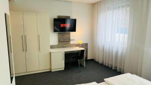 纽伦堡创意园酒店的客房设有一张桌子,墙上配有电视。