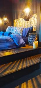 阿特米达Accessible Luxury的一张带蓝色床单和蜡烛及灯光的床