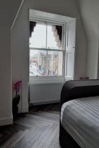 爱丁堡Castle Terrace 1 Bed Apartment Looking onto Edinburgh Castle - Sleeps upto 4的一间卧室设有一张床和一个大窗户