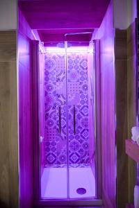 曼弗雷多尼亚B&B Orchidea Celeste的带淋浴的浴室(带紫色照明)
