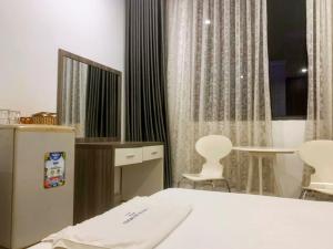 胡志明市White Diamond Hotel - Airport的卧室配有一张床和一张桌子及椅子