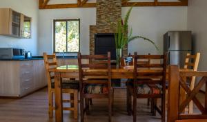 纳库鲁Black Wattle House的厨房配有桌椅和冰箱。