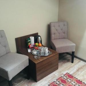 萨拉热窝Al-Dino的客厅配有桌子和两把椅子