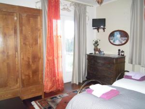 弗拉博萨索塔纳知更鸟酒店的一间卧室配有一张床、一个梳妆台和一扇窗户。