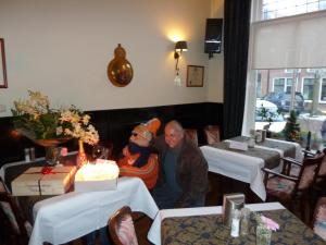 哈林亨中心酒店的老人坐在餐馆里,穿着桑塔西装的男人