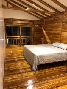 圣维森特Casa de Paz的一间卧室配有一张床,铺有木地板