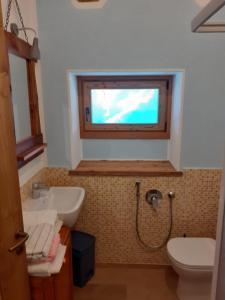RiclarettoLa scuola的一间带水槽和卫生间的浴室以及窗户。