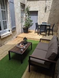 布鲁瓦Appartement au cœur du centre ville de Blois的天井配有沙发和桌子,位于草地上