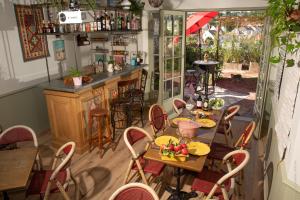 洛什La Little Maison的一间带桌椅的餐厅和酒吧