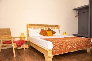 圣路易斯Ndar Ndar House的一间卧室配有一张带枕头和桌子的木床