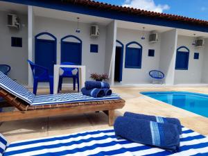 巴雷里尼亚斯Pousada Vila de Charme的别墅 - 带游泳池和蓝色椅子