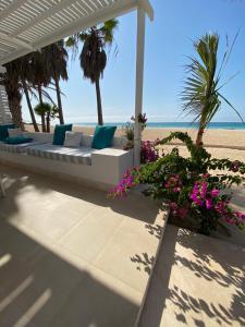 CabeçadasVilla Nº25b Alfredo Marchetti suites on the beach Praia di Chaves的海滩上摆放着白色长沙发,长满了鲜花