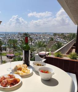 阿尔库迪亚港Tranquilo apartamento con vistas al mar.的一张桌子,上面放着一瓶葡萄酒和盘子