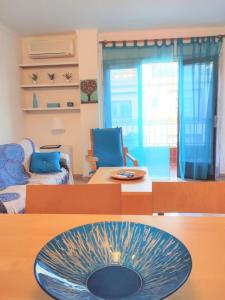 阿尔库迪亚港Tranquilo apartamento con vistas al mar.的客厅,桌子上放着蓝色碗