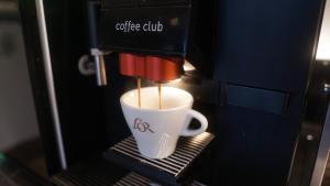 布尔诺Hotel JeštěBrno的咖啡杯在咖啡机里煮