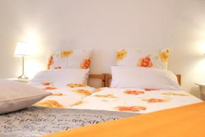 鲁尔河畔米尔海姆Ferienwohnung Heimaterde的一间卧室配有两张带白色床单和橙色鲜花的床。
