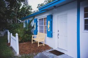 维洛海滩Charming home with hot tub, minutes from the beach的一间蓝色和白色的房子,房子旁边配有椅子