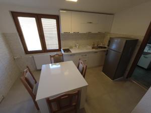 布雷佐维察Mountain House - Brezovica的厨房配有白色的桌子和冰箱。