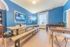 怀特黑Tivoli Guesthouse的一间拥有蓝色墙壁和木桌的用餐室
