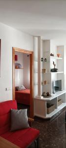 卡索拉Alojamiento Entradita Cazorla的客厅配有红色的沙发和镜子