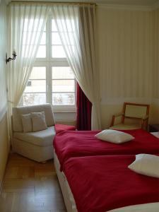 罗斯托克旧海港大厦酒店的一间卧室配有一张床、一张沙发和一个窗口