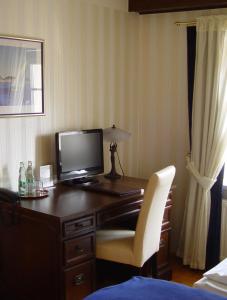 罗斯托克旧海港大厦酒店的客房设有书桌、电视和椅子