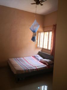 巴马科Résidence Les Fleurettes的一间卧室配有一张带吊扇和窗户的床。