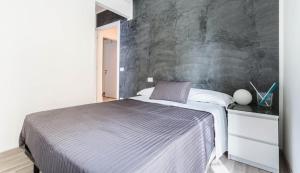 罗马罗马旅馆的一间卧室配有一张带灰色墙壁的床