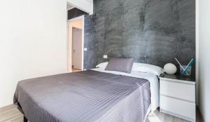 罗马罗马旅馆的一间卧室配有一张带灰色墙壁的床