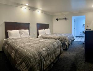 萨克拉门托Capital City Inn Downtown Convention Center的一间酒店客房,设有两张床和走廊