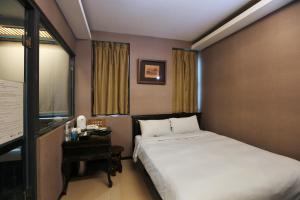 台北山乐温泉酒店的酒店客房设有一张床、一张书桌和窗户。