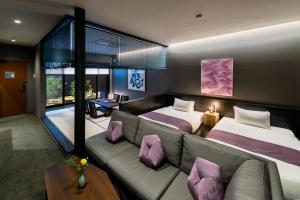 高山THE MACHIYA HOTEL TAKAYAMA的酒店客房,设有两张床和一张沙发