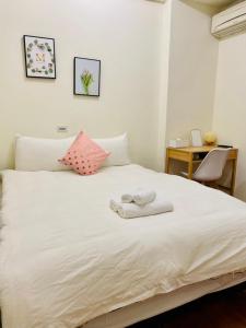 花莲市水上雅居民宿的卧室配有白色床和毛巾