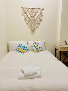 花莲市水上雅居民宿的卧室配有带枕头和吊灯的白色床。