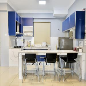 怡保Casahome by Irdina Meru- 8pax -10pax的厨房配有蓝色橱柜和酒吧凳子