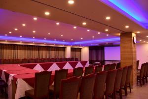 巴纳内拉斯新城国际酒店的一间会议室,配有桌椅和紫色灯