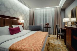 斯利亚奇Wellness & Spa Hotel Kaskady的配有一张床和一张书桌的酒店客房