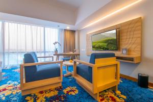 马贾伦卡Hotel Horison Ultima Kertajati的酒店客房设有两把椅子和电视