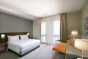 迪拜Hyatt Place Dubai Wasl District Residences的卧室配有一张白色的大床和一张沙发。