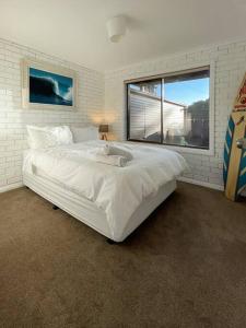 Cape WoolamaiIsland Retreat in Cape Woolamai的卧室设有一张白色大床和一扇窗户。