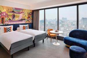 雅加达ibis Styles Jakarta Tanah Abang的酒店客房,配有两张床和椅子