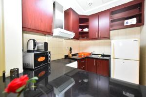 迪拜Budget-Friendly Studio Near Metro - Spacious & Calm - VRN的厨房配有木制橱柜和白色冰箱。