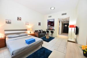 迪拜Budget-Friendly Studio Near Metro - Spacious & Calm - VRN的一间卧室设有一张床和一间客厅。