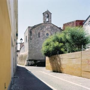 奥里斯塔诺Monastero Santa Chiara Guest House的一条小巷,有一座古老的建筑,有钟楼